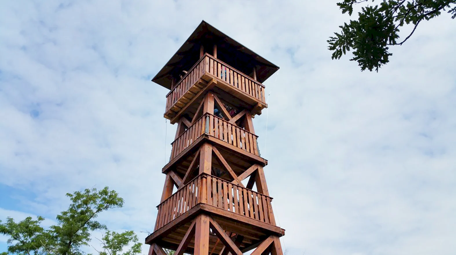 Z rozhľadne nad obcou vidieť maďarské pohoria i Zobor
